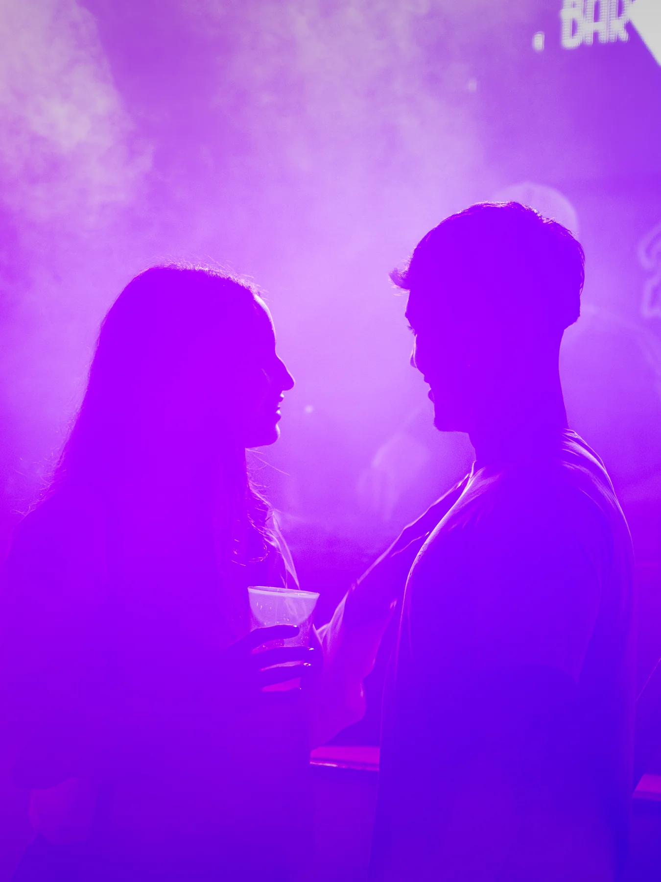 Dos siluetas entre humo violeta