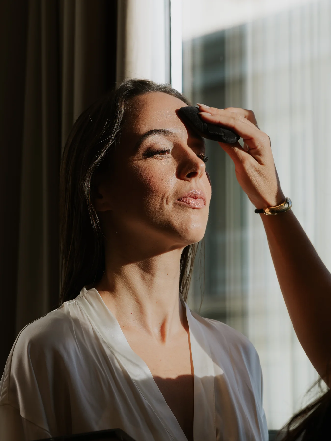 La novia con los ojos cerrados, con la luz de la ventana en la cara