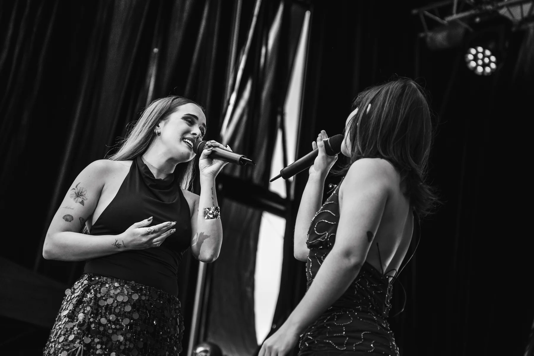Sofía Dorta y Jhemma cantando juntas, en blanco y negro